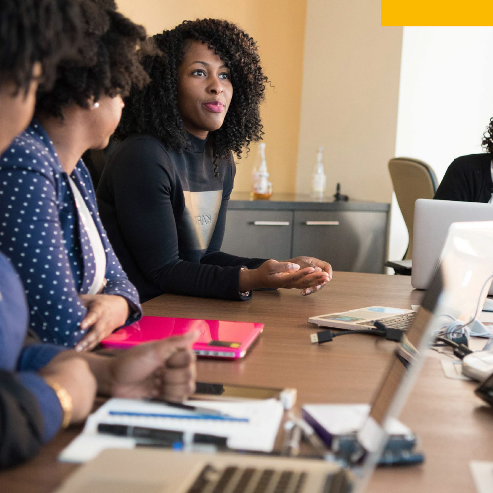 professional women sit around a conference table strategizing